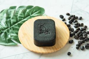 Coffee bean soap bar as homemade, show word meaning natural 100 percentage on white table photo