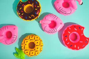Swimming Pool from Top View Colorful Inflatable Rubber Rings with fun patterns. Clean blue water pool summer background. Perfect for summer parties, beach holiday design photo