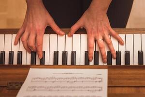 pianist playing the piano, close up view of hands and keys photo