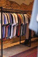 A stylish boutique showcases an array of vibrant hanging Tshirts in a wellorganized display photo