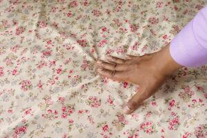 man Hand touching and pressing orthopedic mattress on bed. photo
