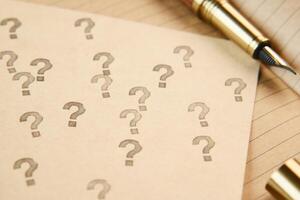 high angle view of question mark on paper on office desk photo