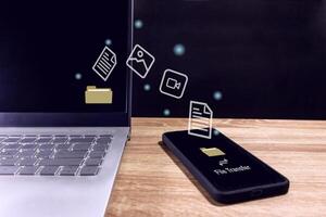 File transfer between smartphone and laptop. Copy file and media or exchange data concept. photo