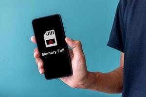 Man holding a smartphone with memory space full notification on screen photo