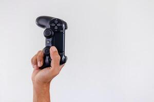 Hand holding a gamepad controller or joystick on a white background photo