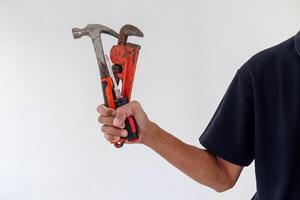 Man holding hammer, screwdriver, and pipe wrench on a white background photo