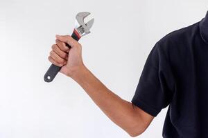 Man holding an adjustable wrench or adjustable spanner isolated on white background photo