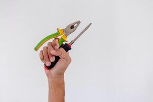 Hand holding screwdriver and pliers isolated on white background photo
