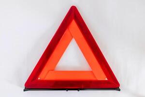 Red warning triangle or reflective road hazard warning triangle on a white background photo