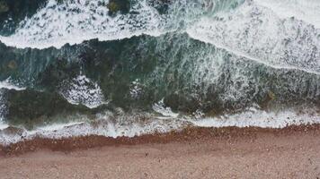 A view of the ocean and waves crashing against the rocky shore with white foam video