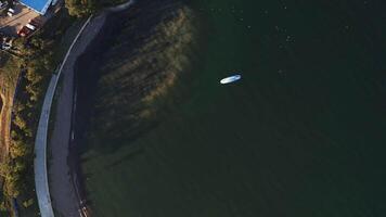 Aerial view of a paraglider with an engine flying by the coast of the sea video
