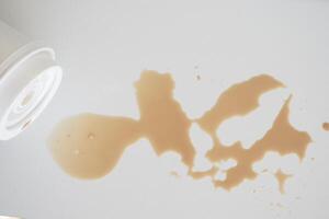 A drink was accidentally spilled on a desk with a laptop and glasses, creating a mess photo