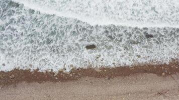 A view of the ocean and waves crashing against the rocky shore with white foam video