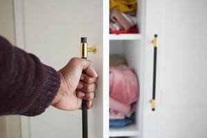 The closet has efficiently arranged shelves with neatly folded clothes when opened photo
