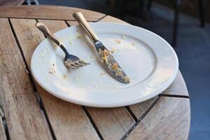 An empty dirty plate with a fork. photo