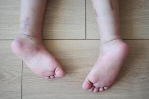 Bare feet of a child on a wooden floor represent innocence and playful moments at home photo