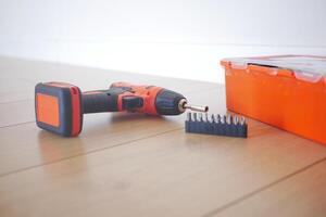 An electric screwdriver is on the floor, photo
