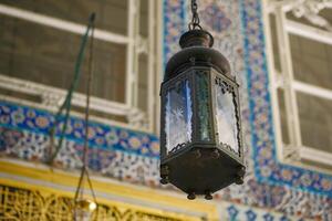 Ornate lantern with vibrant tile background, intricate craftsmanship and traditional design photo