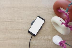 charging Smartphone using Wireless Charging Pad, top view photo