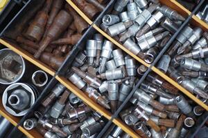 An assortment of metal nuts and bolts stored in a storage bin for construction and repair projects photo