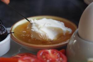 butter cream and honey in a bowl on table . photo