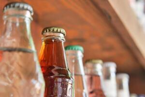 Vintage beverage bottles with colorful caps on bar shelf create a nostalgic retro drinks display photo