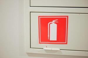 The store aisle is marked with a sign indicating the presence of a fire extinguisher and fire hose photo