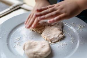 Child having fun modeling salt dough, authentic activity, fine motor skills development photo