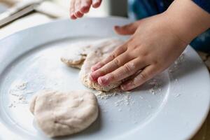 Child having fun modeling salt dough, authentic activity, fine motor skills development photo