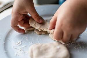 Child having fun modeling salt dough, authentic activity, fine motor skills development photo