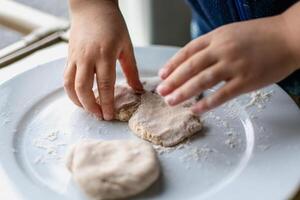 Child having fun modeling salt dough, authentic activity, fine motor skills development photo