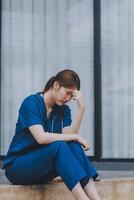 Stressed doctor sitting in front of office, working pressure. photo