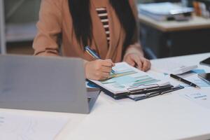 Business woman accountant working audit and calculating expense financial annual financial report balance sheet statement, doing finance making notes on paper checking document. photo