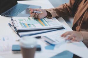 Business woman accountant working audit and calculating expense financial annual financial report balance sheet statement, doing finance making notes on paper checking document. photo