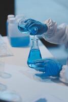 Group of dedicated scientist conduct chemical experiment in medical laboratory, carefully drop precise amount of liquid from pipette into test tube for vaccine drug or antibiotic development. Neoteric photo