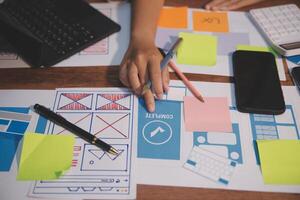 The designer team is designing the uxui system to make the uxui system work well on new phones and support system updates. Website development concept UI UX front end designer photo