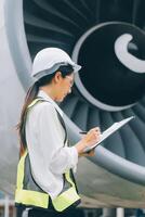 Technician fixing the engine of the airplane,Female aerospace engineering checking aircraft engines,Asian mechanic maintenance inspects plane engine photo