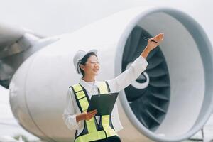 Technician fixing the engine of the airplane,Female aerospace engineering checking aircraft engines,Asian mechanic maintenance inspects plane engine photo