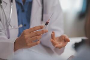 Doctor uses hypodermic needle and syringe to put a dose of medicine as treatment. photo