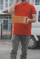 Asian delivery express courier young man use giving boxes to woman customer he wearing protective face mask at front home photo