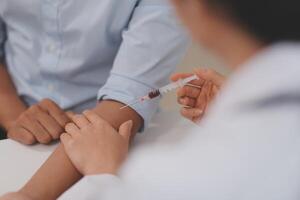 Doctor uses hypodermic needle and syringe to put a dose of medicine as treatment. photo