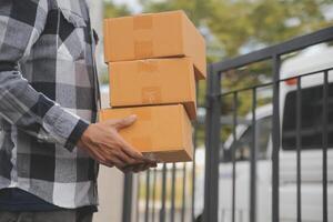 Asian delivery express courier young man use giving boxes to woman customer he wearing protective face mask at front home photo