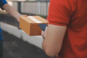 Asian delivery express courier young man use giving boxes to woman customer he wearing protective face mask at front home photo