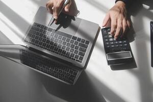 businessman working on desk office with using a calculator to calculate the numbers, finance accounting concept photo