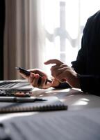 Side view shot of a man's hands using smart phone in interior, rear view of business man hands busy using cell phone at office desk, young male student typing on phone sitting at wooden table, flare photo