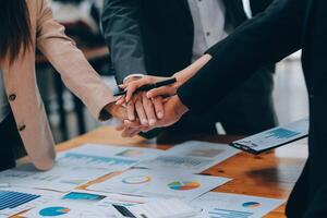 Motivated successful business team giving high five, happy young students employees group join hands with senior teacher mentor, team building unity concept, help support in teamwork, close up view photo