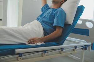 Seriously Ill Man Lying on a Bed in the Hospital. Monitors Show His Vital Signs. Ward is Clean and New. photo