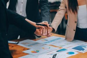 Motivated successful business team giving high five, happy young students employees group join hands with senior teacher mentor, team building unity concept, help support in teamwork, close up view photo