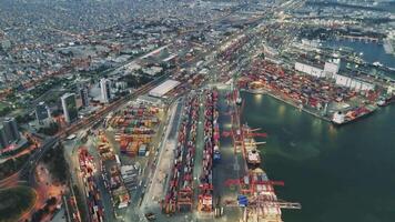 Drone films the seaport at sunset, capturing the busy container terminal. Containers are stacked and ready for shipping. The showcases the efficiency and scale of container handling at seaport video
