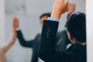 Motivated successful business team giving high five, happy young students employees group join hands with senior teacher mentor, team building unity concept, help support in teamwork, close up view photo